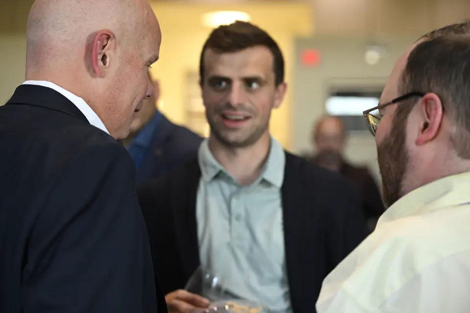Three men converse in a tight circle.