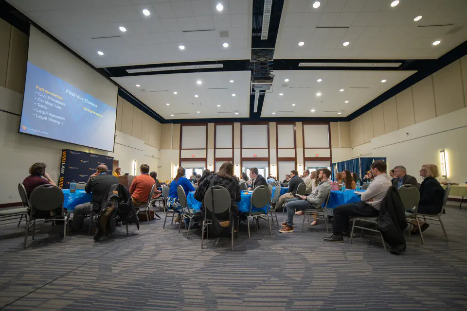 WVU Law faculty sit in an event hall space in the College of Law.
