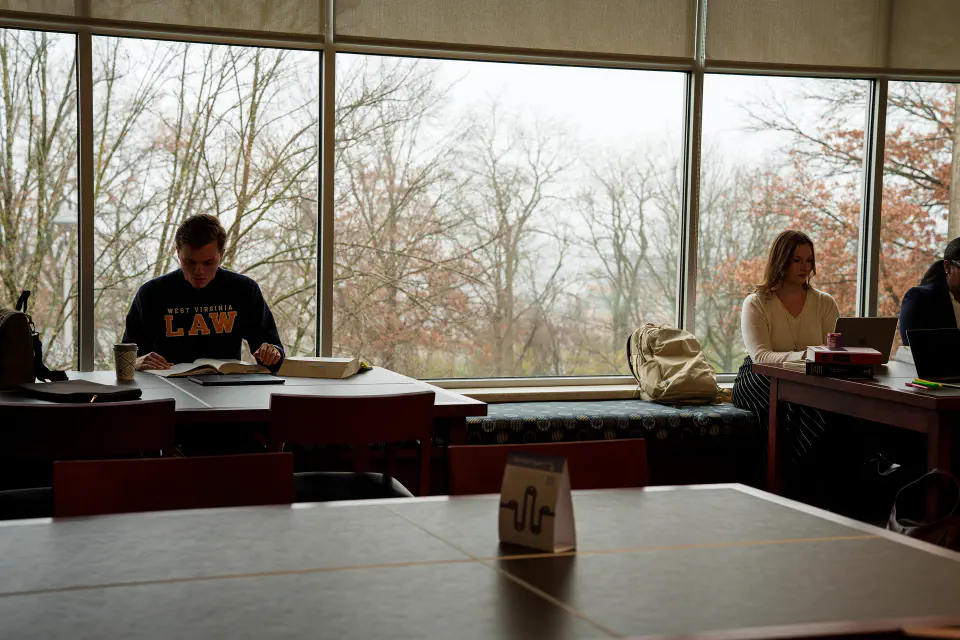 WVU Law students sit near the windows on the top floor library.