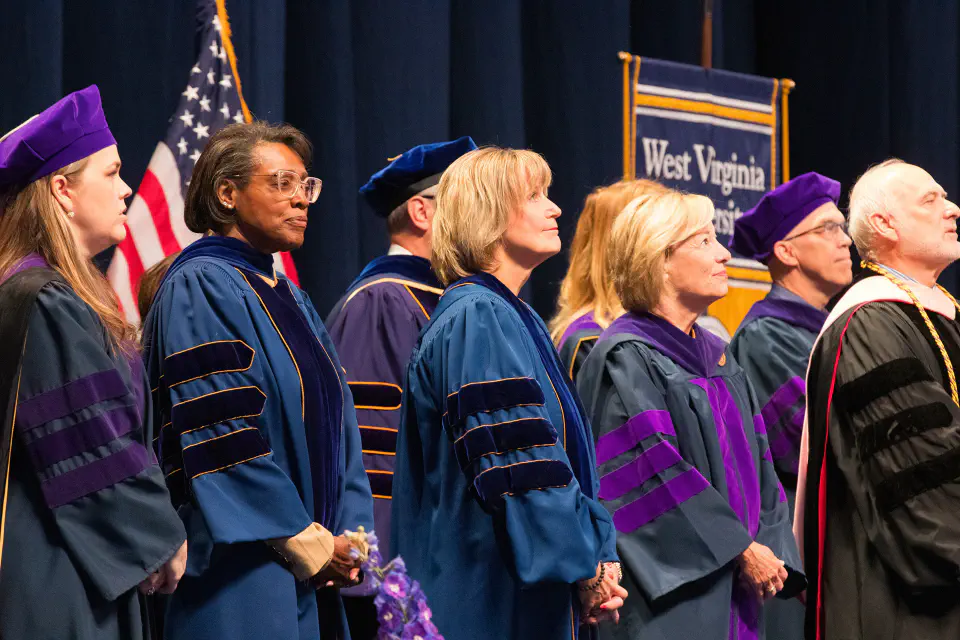 Photo of WVU Law interim dean Susan Brewer, Senior Justice Beth Walker, and Dr. Elizabeth Dooley standing on stage.