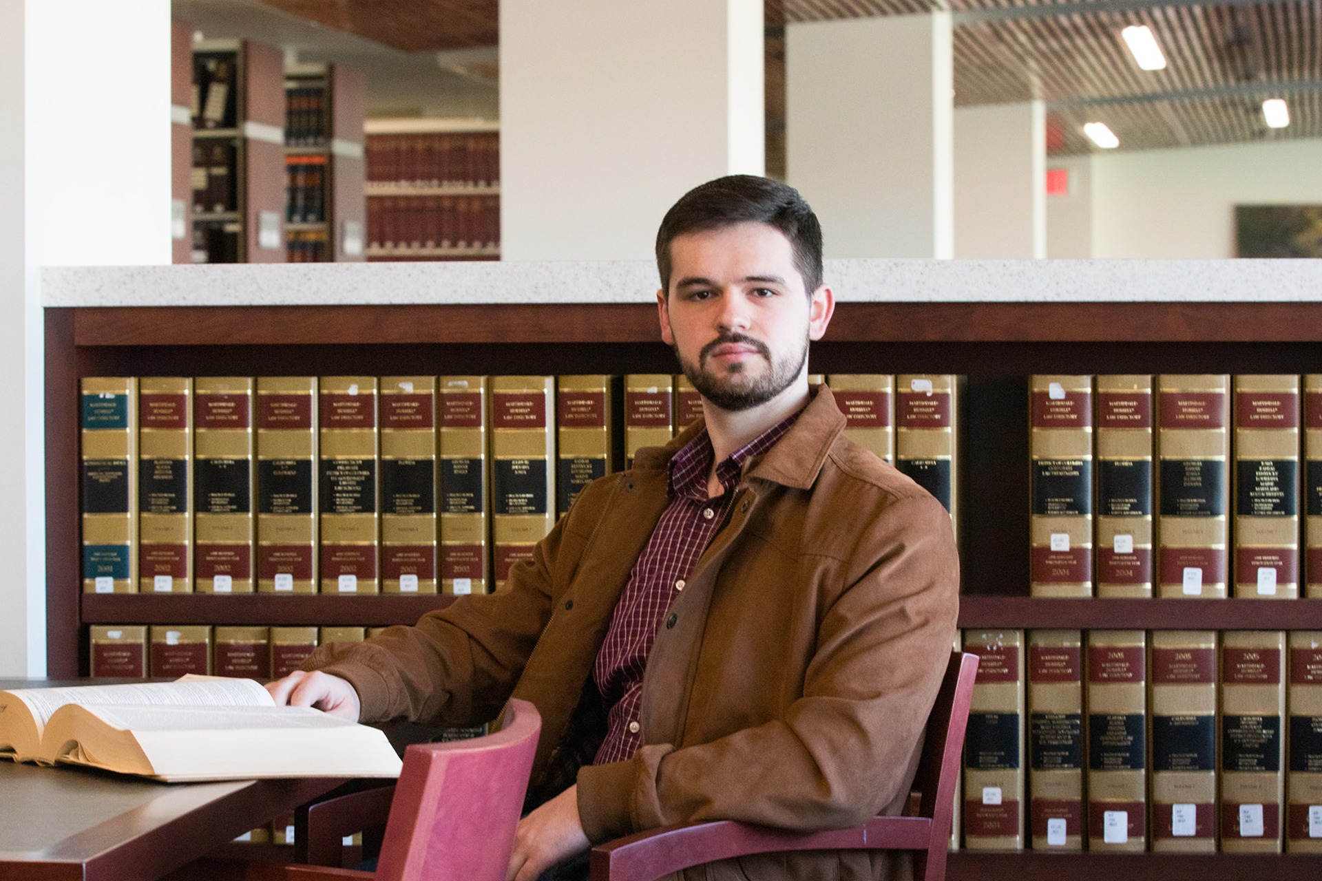 Photo of WVU Law student Grant Joynes reading a book in the WVU Law Library.