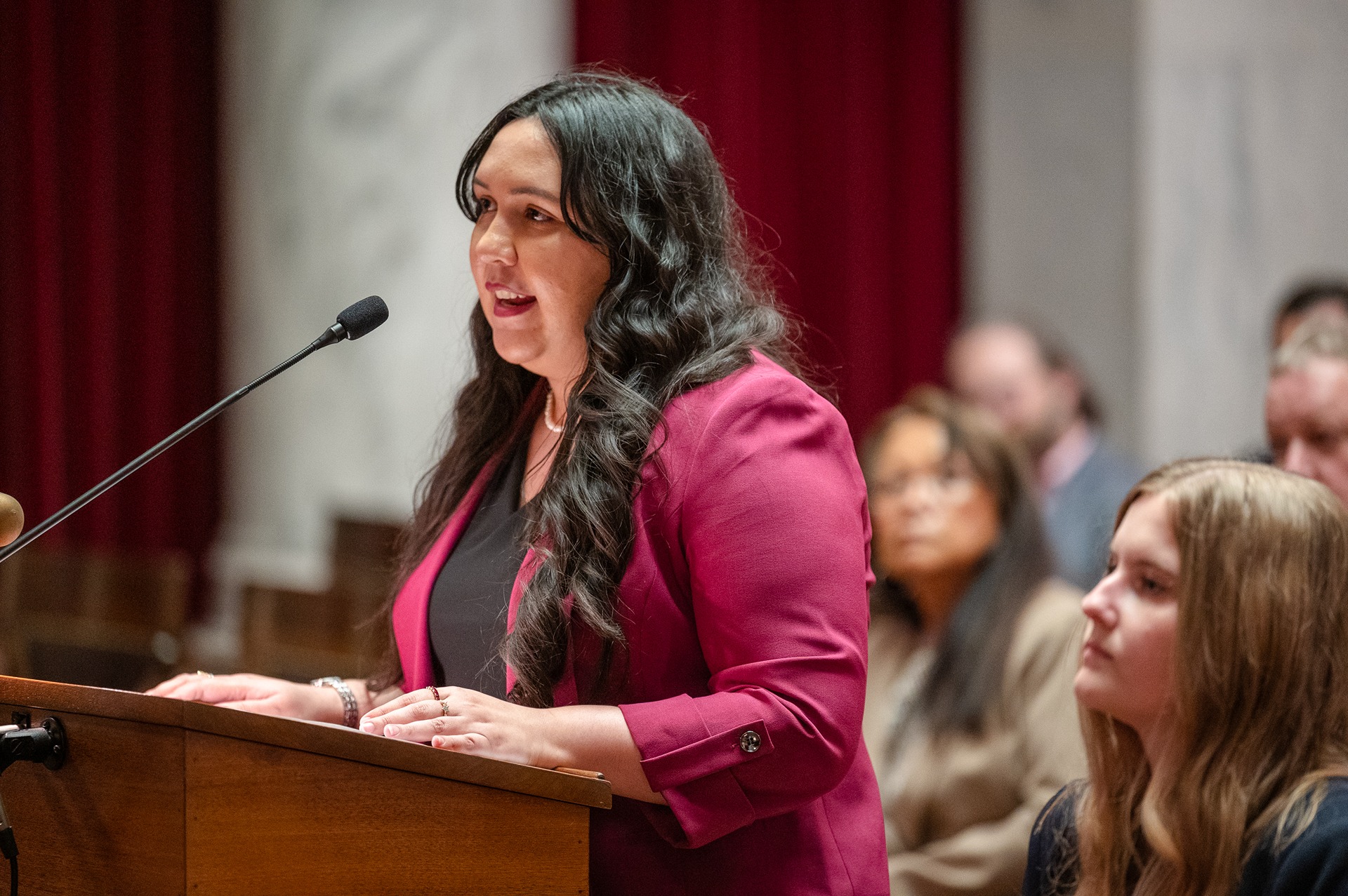 Photo of WVU Law student Kaitlyn Nedrow speaking at a podium at the WV Supreme Court.