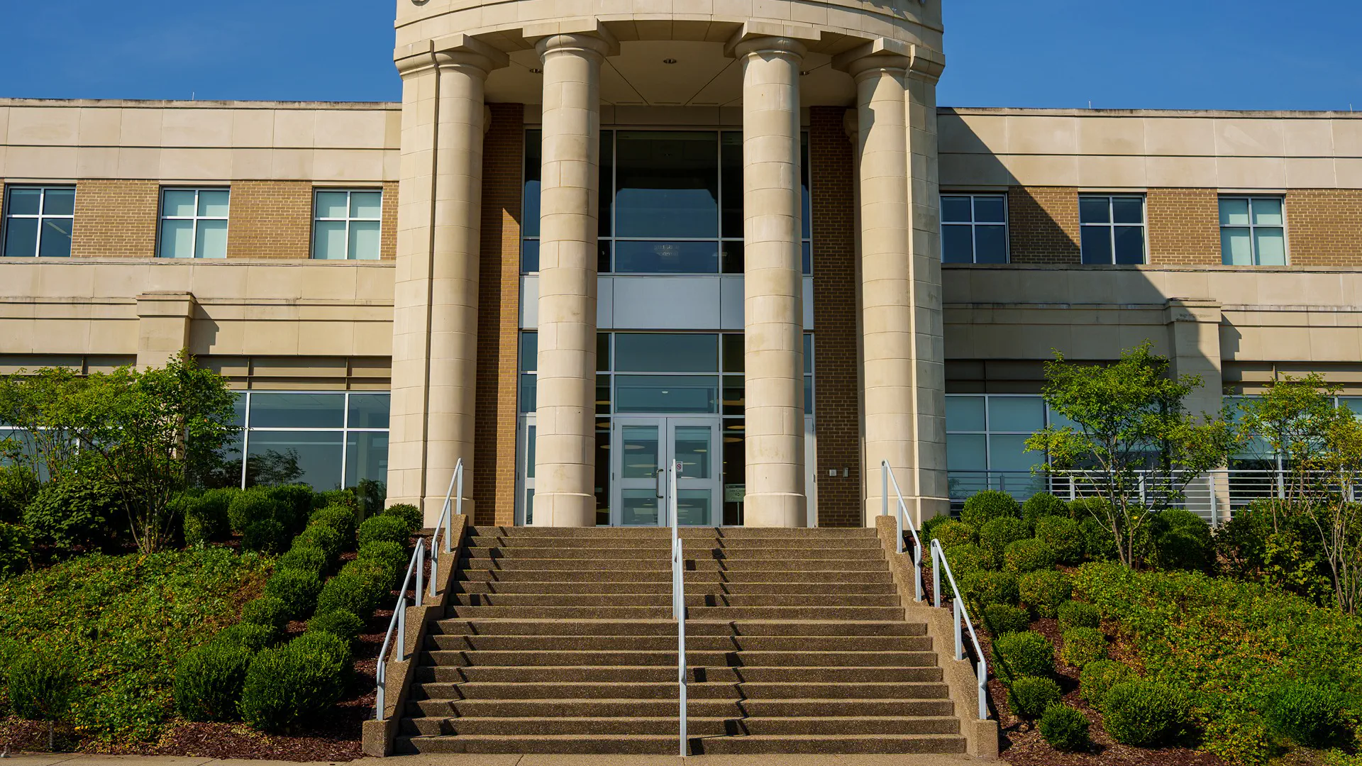 Front entrance of the WVU College of Law, featuring a set up steps and large pillar columns.